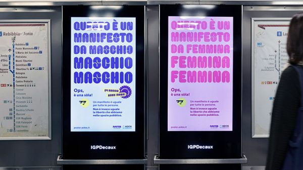 immagine di due monitor in metropolitana a Roma che visualizzano la campagna nei due soggetti "da maschio" e "da femmina", in uno la scritta "questo manifesto è da maschio", nell'altro "questo manifesto è da femmina"